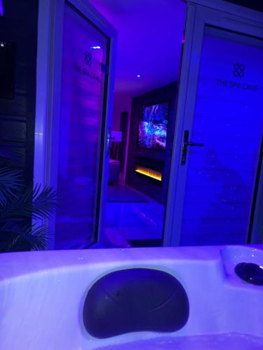 a bathroom with a tub with a sink and a television at The_Spa_Cave in Murroes