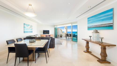 Un comedor y una sala de estar con mesa y sillas. en Unit 46 - 3 Bed Ocean View, en Terrigal
