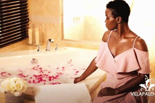 a woman in a pink dress standing next to a bath tub at Casa de Palencia-Luxury By The Beach-Silver Sand Estate -Entire Villa in Bamboo