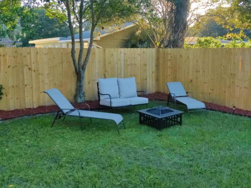 three chairs and a table in a yard with a fence at Roosevelt Inn in Jacksonville