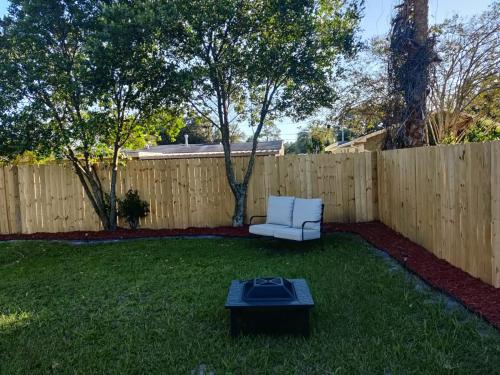 a backyard with a white chair and a table at Roosevelt Inn in Jacksonville