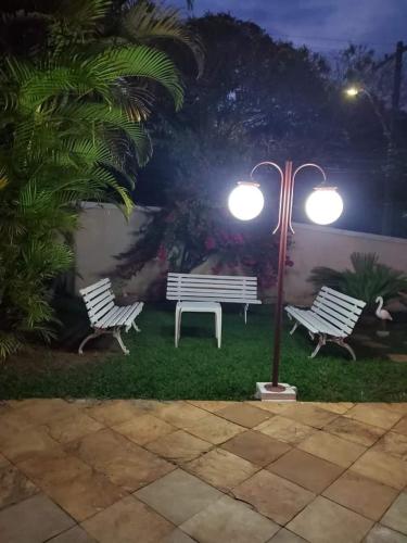 two park benches and a light pole at night at Casa Pampulha in Belo Horizonte
