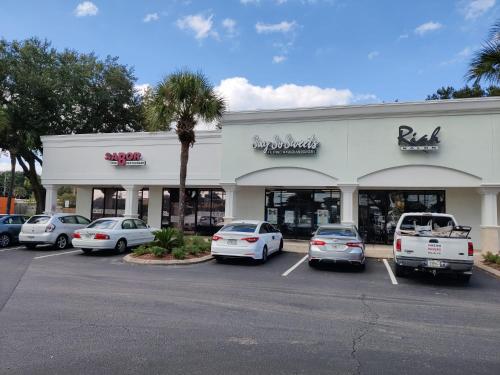 a store with cars parked in a parking lot at Roosevelt Inn in Jacksonville