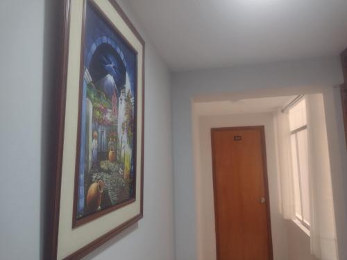 a painting hanging on a wall next to a door at Casa de Isabel in Arequipa