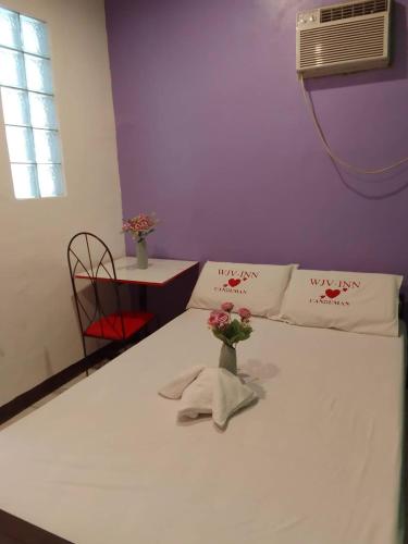 ein Zimmer mit einem Bett mit einer Blumenvase darauf in der Unterkunft WJV INN Canduman in Mandaue City