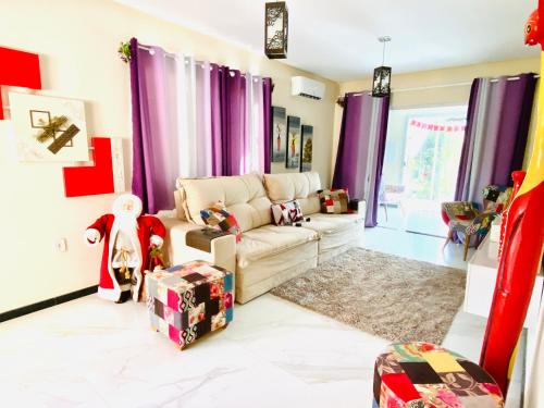 a living room with purple curtains and a couch at Villa Paradise in Brazil - Praia de Guaratiba Prado-BA in Prado