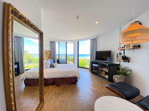 a large mirror in a room with a bed and a television at Minimi Inn-Sailrock Beach House in Eluan