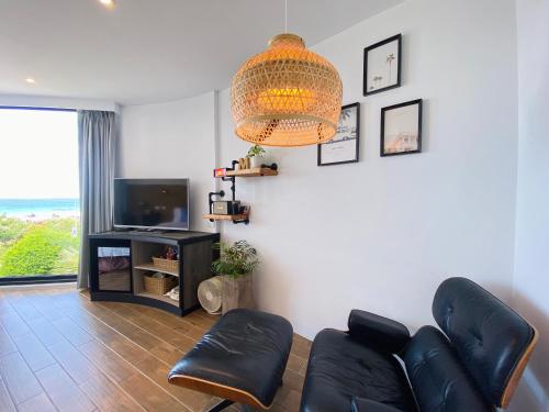a living room with a couch and a television at Minimi Inn-Sailrock Beach House in Eluan