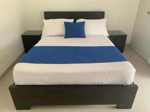 a large bed with blue and white sheets and pillows at Seway Morros Cartagena in Cartagena de Indias