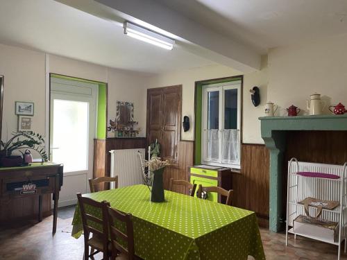 une cuisine avec une table et un tissu de table vert dans l'établissement Maison de Campagne Familiale avec Mini-Ferme et Activités pour Enfants - FR-1-489-121, à Saligny-sur-Roudon