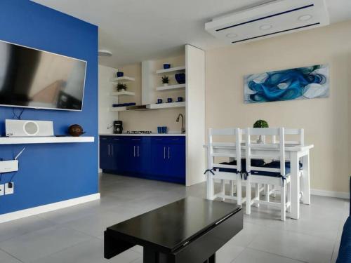 a living room with a table and a blue wall at Departamento moderno in Ciudad Juárez