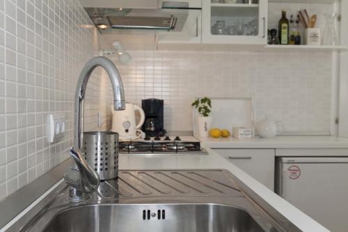 uma cozinha branca com um lavatório e um fogão em Suncana Apartments Dubrovnik em Dubrovnik