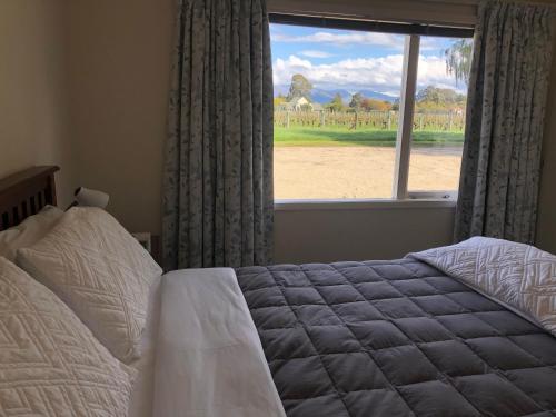 A bed or beds in a room at Vineyard Cottage in Blenheim on the Golden Mile