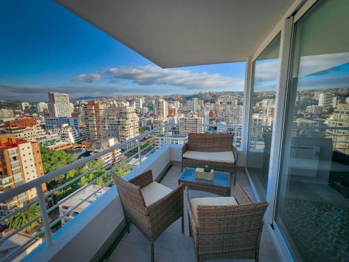 einen Balkon mit Stühlen und einem Tisch auf einem Gebäude in der Unterkunft Cómodo departamento familiar a pasos de la playa in Viña del Mar
