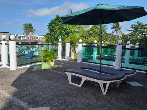 a bench with an umbrella on top of a building at Turtle Inn Resort in Boracay
