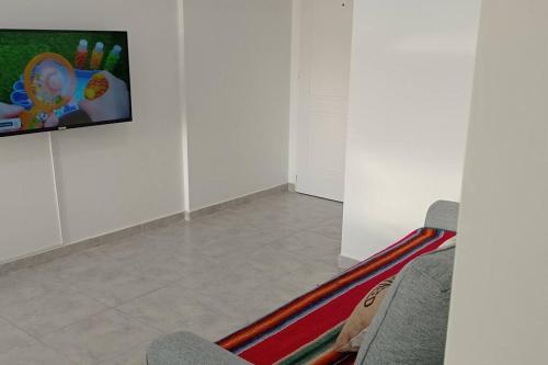 Habitación con 2 sillas y TV en la pared. en Departamento completo en excelente zona en Paraná