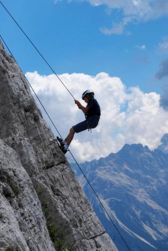 a man standing on a rope on a mountain at Dolasilla Park Hotel in Vigo di Fassa