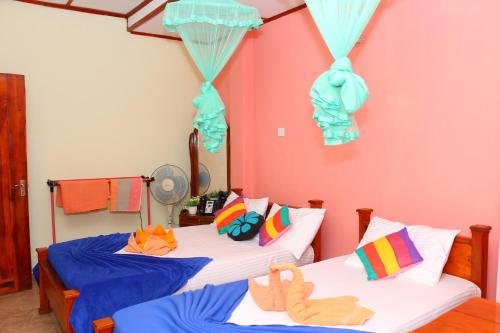 two beds with stuffed animals on them in a room at Little Heaven in Ella