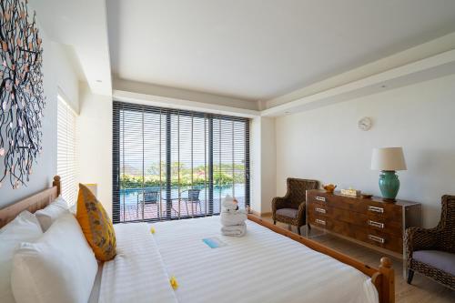 a bedroom with a bed and a large window at Moritz Palm Villa in Uluwatu