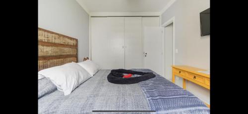 a bedroom with a bed with a stuffed animal on it at Lindo flat no Guarujá in Guarujá