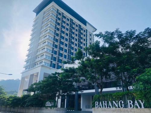 een hoog gebouw met een bord ervoor bij Bahang Bay Hotel in Batu Ferringhi