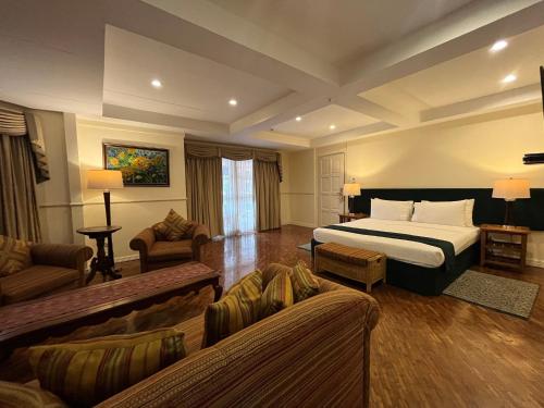 ドゥマゲテにあるCoco Grande Hotelのベッドとソファ付きのホテルルーム