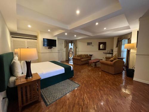 a hotel room with a bed and a living room at Coco Grande Hotel in Dumaguete