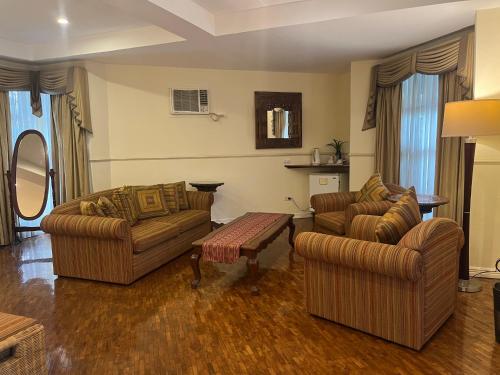 a living room with two couches and a table at Coco Grande Hotel in Dumaguete