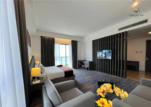 a hotel room with a bed and a living room at Bahang Bay Hotel in Batu Ferringhi