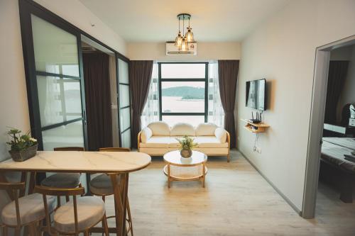 een woonkamer met een tafel en een bank bij TF Sunset Ocean View Homestay - Jesselton Quay in Kota Kinabalu