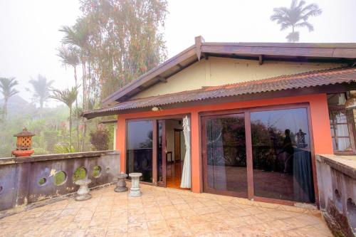 a house with glass doors on the side of it at Pacung Indah Hotel & Restaurant by ecommerceloka in Bedugul