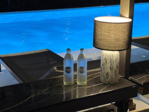 two bottles on a table in front of a television at POR Santitham in Chiang Mai