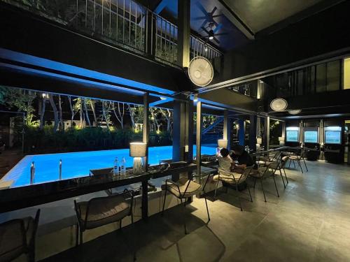 a restaurant with a pool in the middle of a building at POR Santitham in Chiang Mai