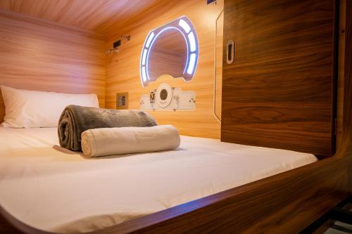 Ce lit se trouve dans une petite chambre dotée d'une fenêtre. dans l'établissement Jpod Capsule Hotel, à Kota Kinabalu