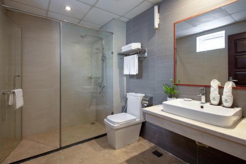 a bathroom with a shower and a toilet and a sink at Skylark Hotel in Hanoi