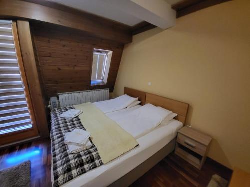 una camera con letto e lenzuola bianche di Apartment 311 Aparthotel Vučko Jahorina a Jahorina