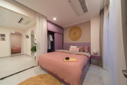a bedroom with a pink bed with a tray on it at Pavillon Garden Hotel in Nha Trang