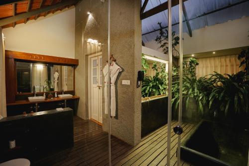 a bathroom with a shower and a robe on a wall at SpiceTree Rajakumari in Munnar