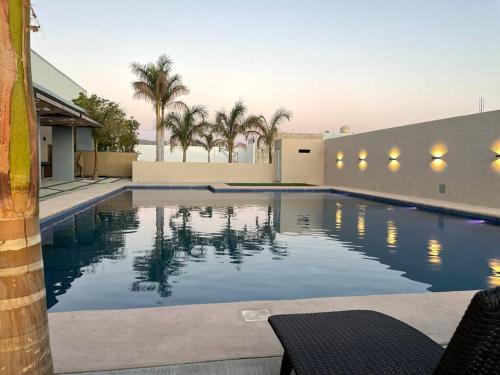 a swimming pool with palm trees and a building at Casa Mauricio in La Paz