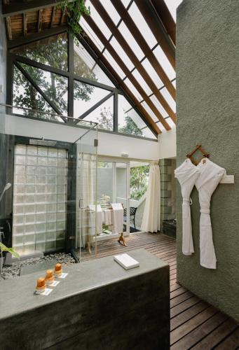 a bathroom with a glass shower and a bath tub at SpiceTree Rajakumari in Munnar