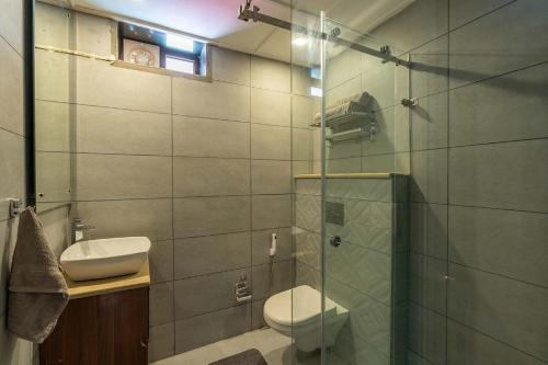 a bathroom with a toilet and a glass shower at StayVista at Arncliff Villa 5 Mins from Mall Road in Mussoorie