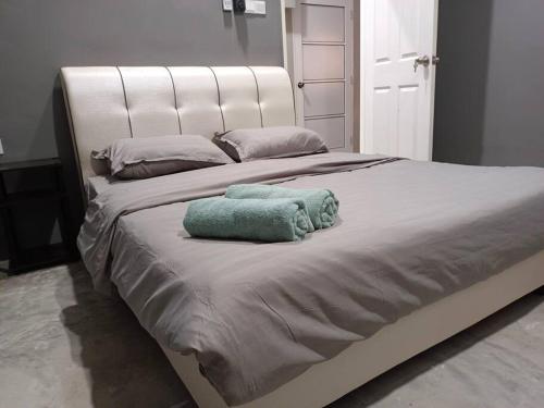 a large white bed with two towels on it at Impian Stay 0.1 Townhouse with 3 bedrooms. in Kuah
