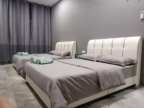 two beds sitting next to each other in a room at Impian Stay 0.1 Townhouse with 3 bedrooms. in Kuah