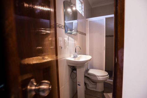 uma casa de banho com um WC branco e um lavatório. em Habitación privada en el centro de Tequila em Tequila