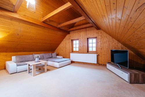 a large living room with a couch and a tv at Andělský Dvůr in Světce