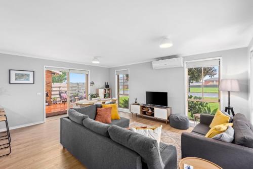 a living room with two couches and a tv at Parrwang Rest in Portarlington