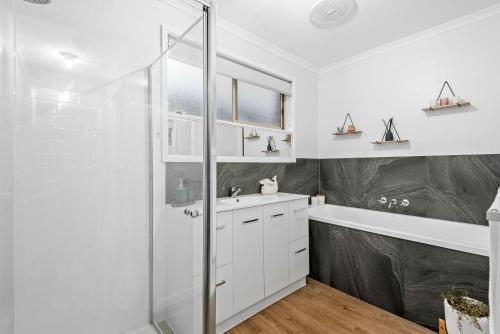 baño blanco con ducha y lavamanos en Parrwang Rest, en Portarlington