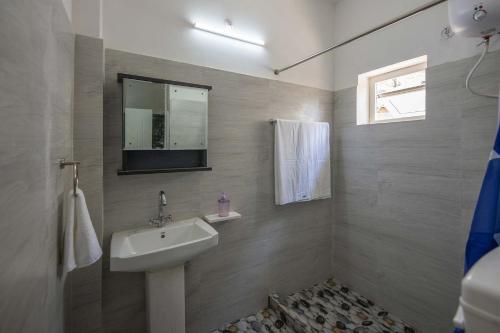baño con lavabo y TV en la pared en StayVista at Pines & Spruce - Exclusive getaway, en Lansdowne