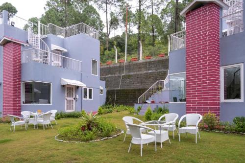 a group of houses with chairs and tables in the yard at StayVista at Pines & Spruce - Exclusive getaway in Lansdowne