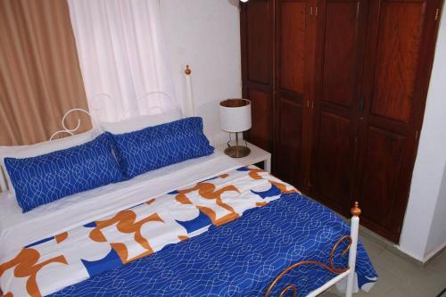 a bedroom with a bed with a blue and white comforter at Dominican Suite 23, Incredible 1 Bed Apt (DS23) in San Felipe de Puerto Plata